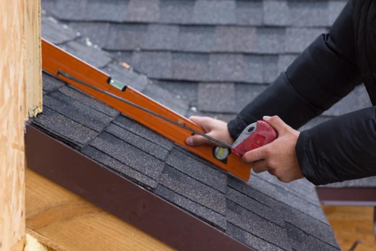 worker taking the roof measurement with a tape measure