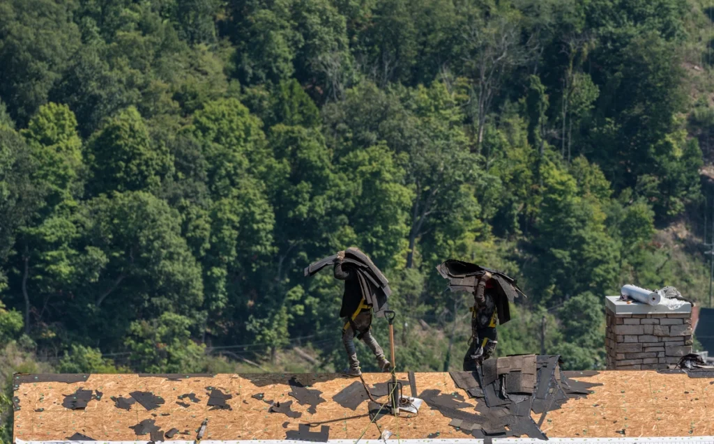 professional workers on the roof carrying the asphalt shingles
